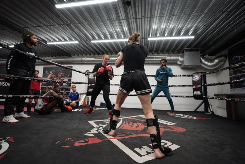 Sporters trainen in de eigen ring van Simson Gym onder het toeziend oog van een trainer